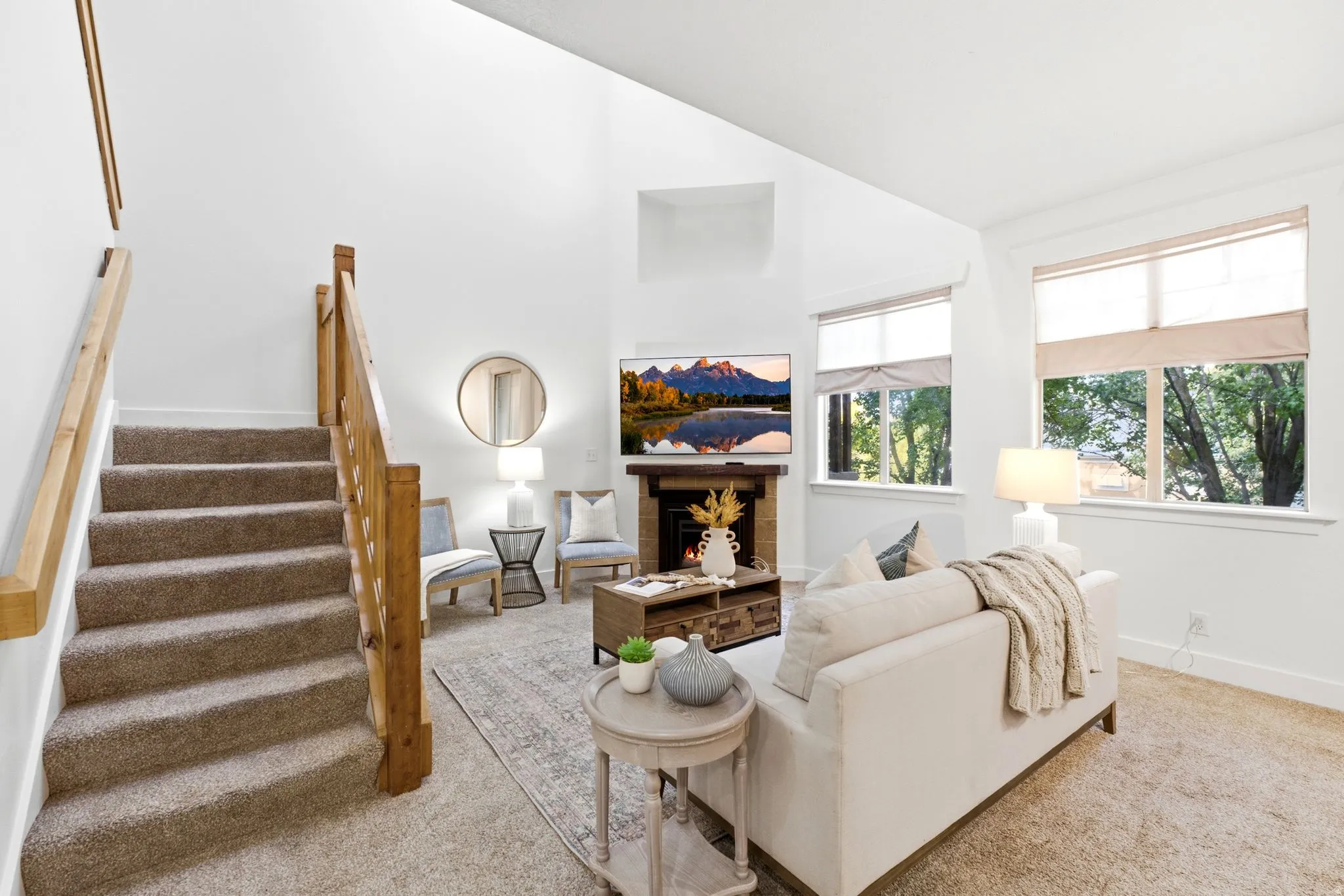 Vaulted ceilings, a built-in fireplace, natural wood staircase, and abundant natural light from multiple windows