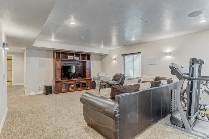 Carpeted living room recessed lighting, and a window with blinds