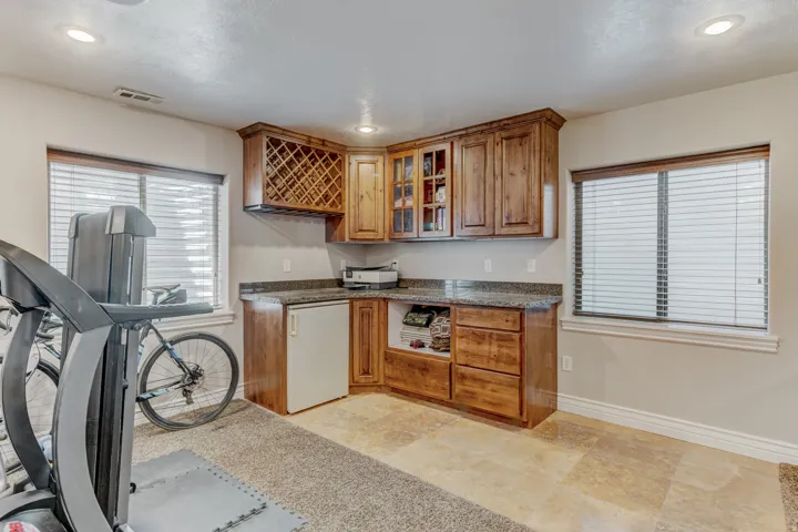Built-in cabinetry with wood-finish doors, granite-look countertops, and an integrated wine rack