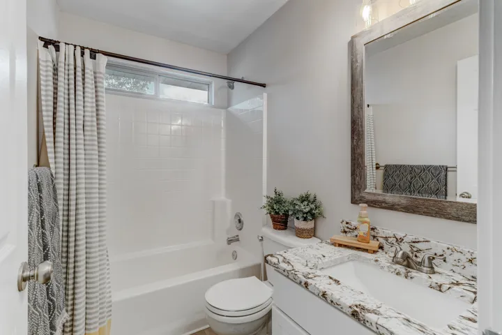 Bathroom featuring a white vanity with a granite countertop, undermount sink, and brushed nickel faucet