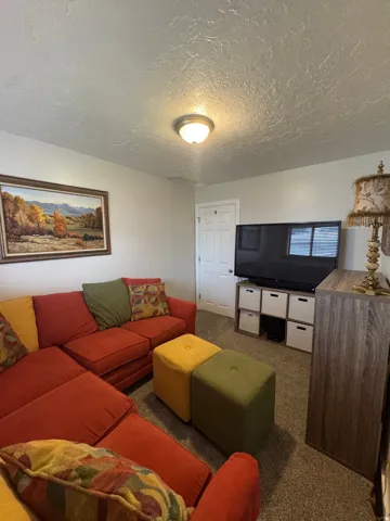 Wall-to-wall carpeting with light-colored walls and a textured ceiling