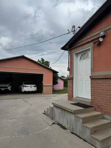 Concrete steps leading to a white entry door with a half-round transom window, brick facade detailing, and an attached two-car garage
