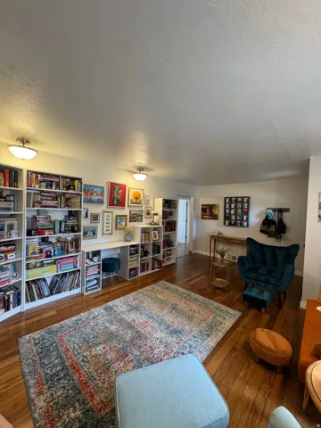 Wood-finish flooring throughout, complemented by built-in wall-to-wall shelving and a built-in desk
