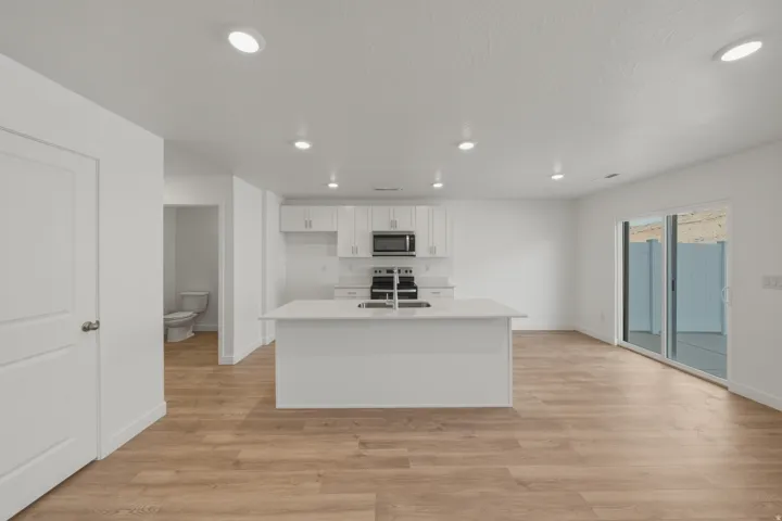 Open-concept room featuring wood-finish flooring, recessed lighting, and white walls
