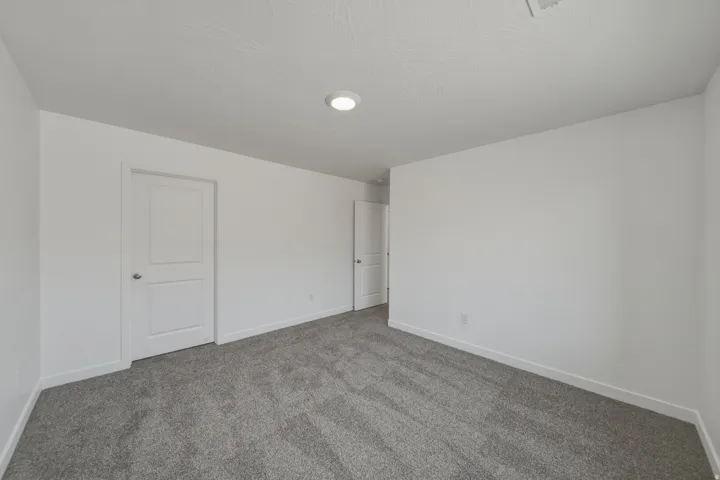 Wall-to-wall carpeting and white walls with recessed lighting
