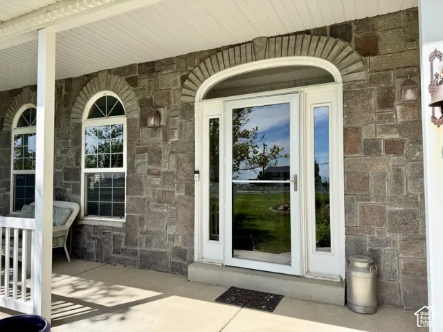 Stone exterior with arched window surrounds and a full-light storm door