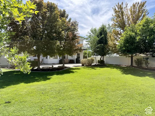 Expansive green lawn with mature trees and a fenced perimeter