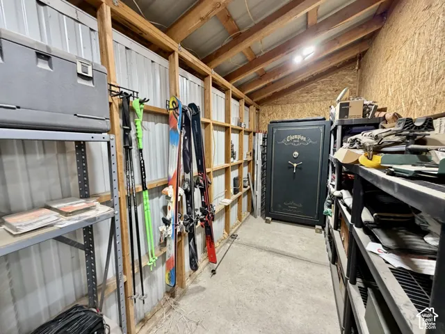 Storage space with exposed wood framing, corrugated metal paneling, and concrete flooring