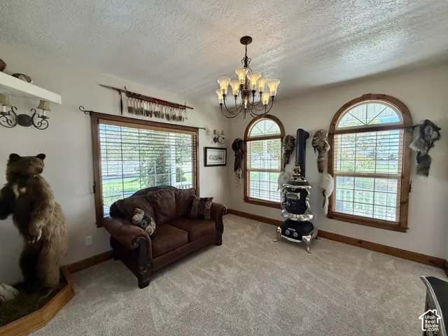 Recessed wall sconces, wood-trimmed windows with arch accents, built-in stove, and a decorative chandelier