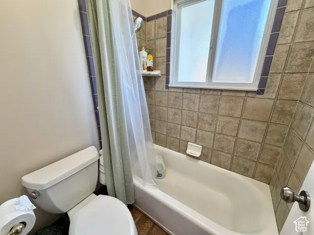 Full Bathroom with Ceramic Tile Surround, Alcove Bathtub with Shower Combination, and Natural Light from Window