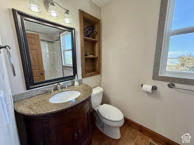 Vanity with a granite countertop, undermount sink, and dark wood-finish cabinetry