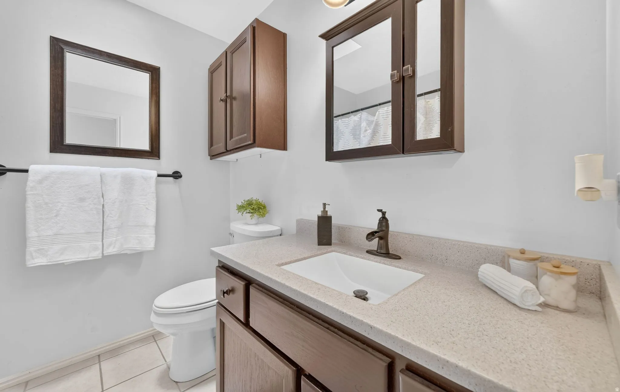 Spa-inspired bathroom featuring a wood-finish vanity with dual storage drawers, a rectangular undermount sink, and a quartz countertop