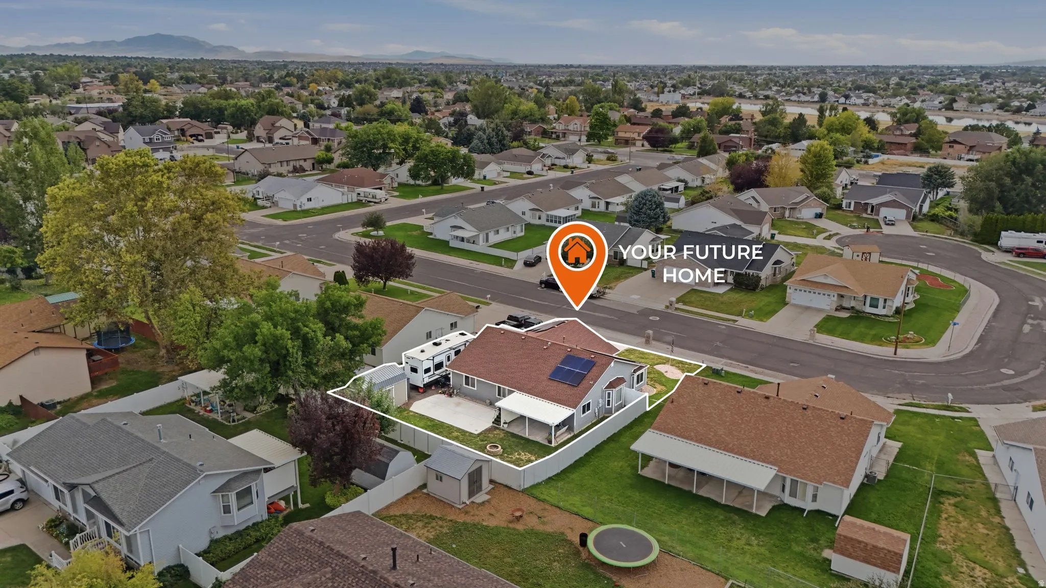 Aerial view showcasing this corner-lot residence with brick exterior, manicured lawn, mature landscaping, and ample driveway parking