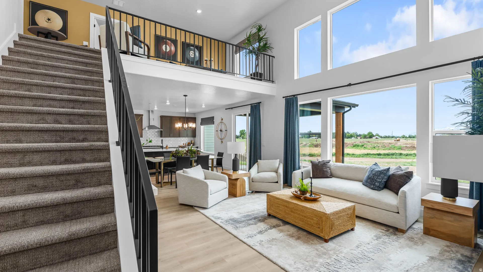 Two-story living area with expansive windows, a second-story balcony, and wood-finish flooring