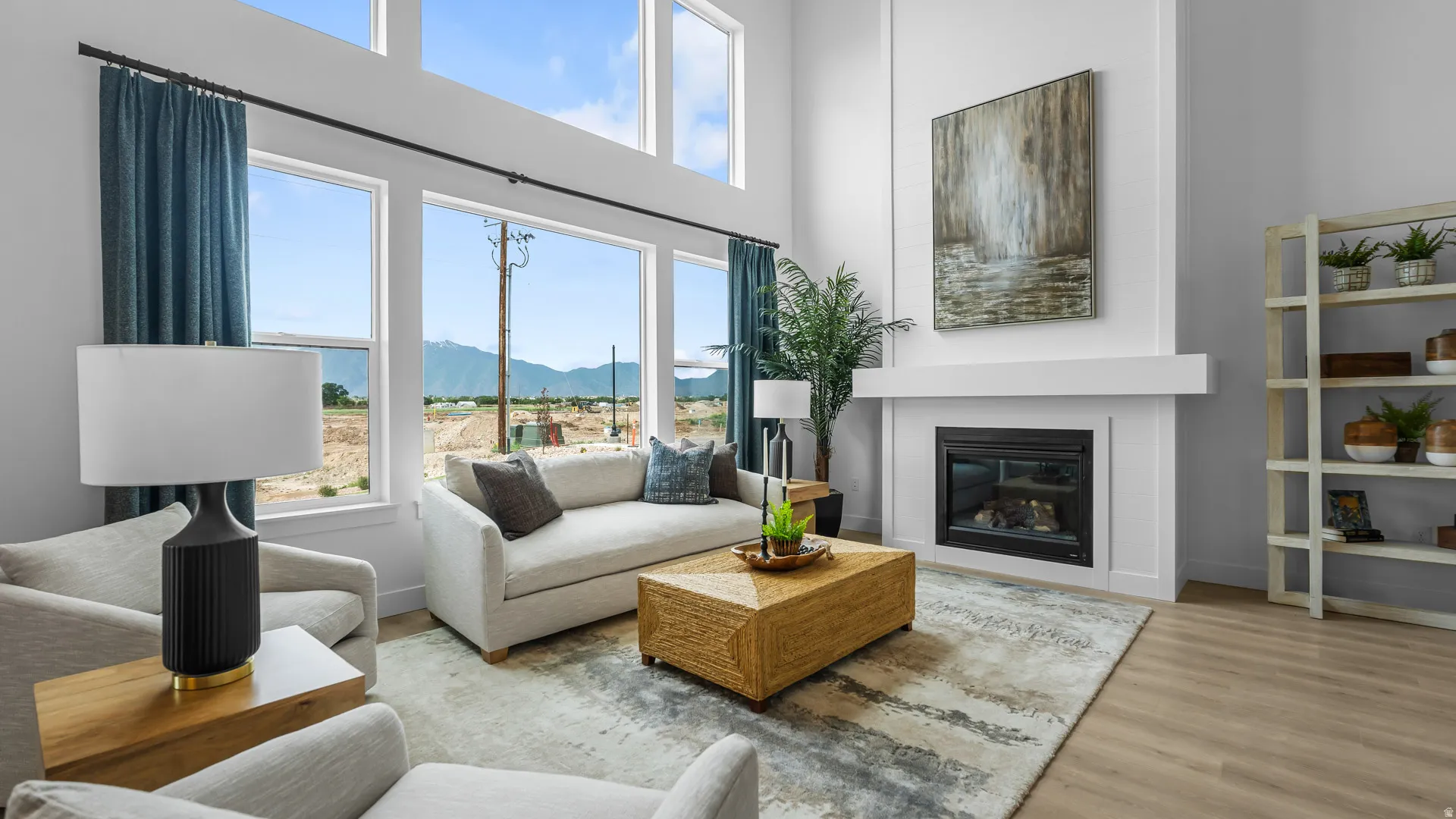 Two-story living area with large windows, a built-in fireplace, and wood-finish flooring