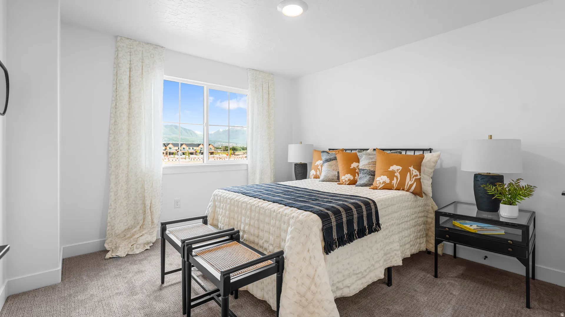 Bright bedroom featuring a large window, neutral carpeting, recessed lighting, and white walls