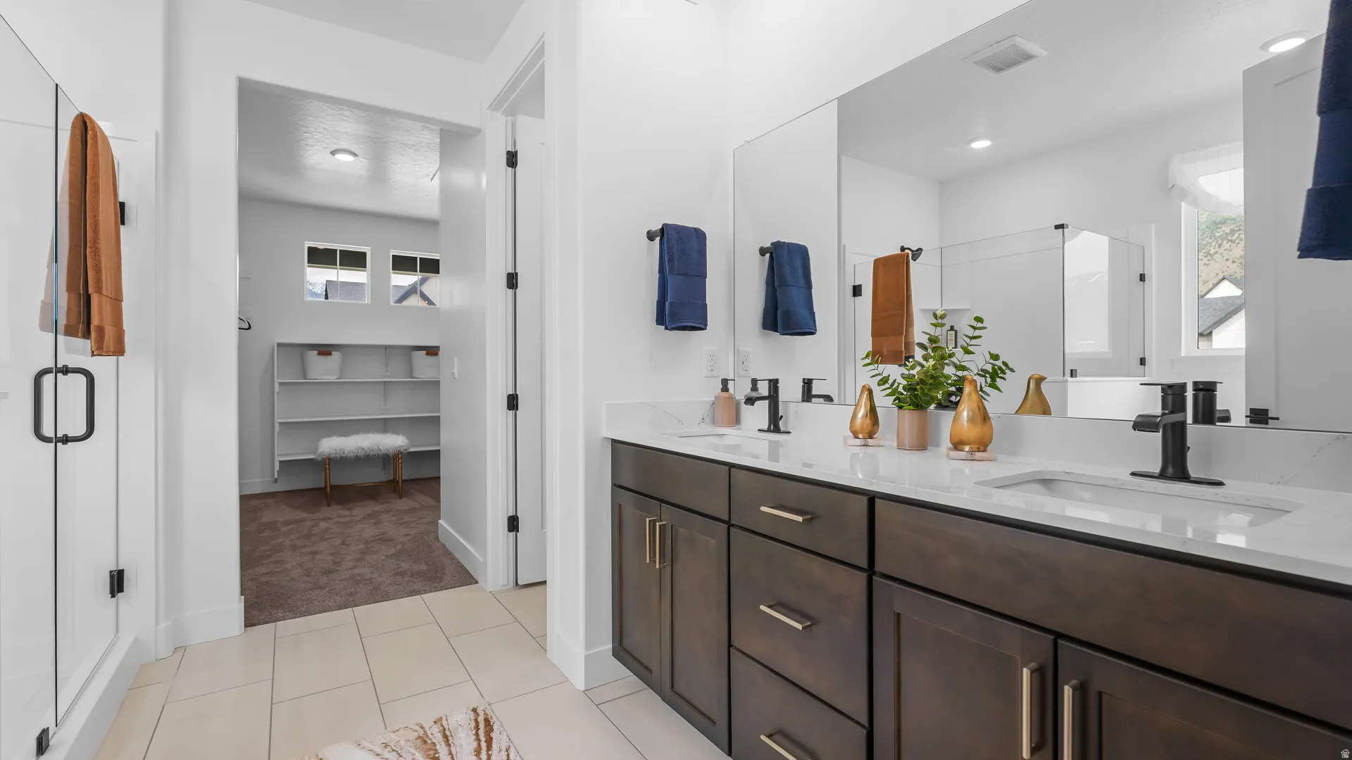 Dual vanity with dark wood-finish cabinetry, white countertop, and matte black fixtures
