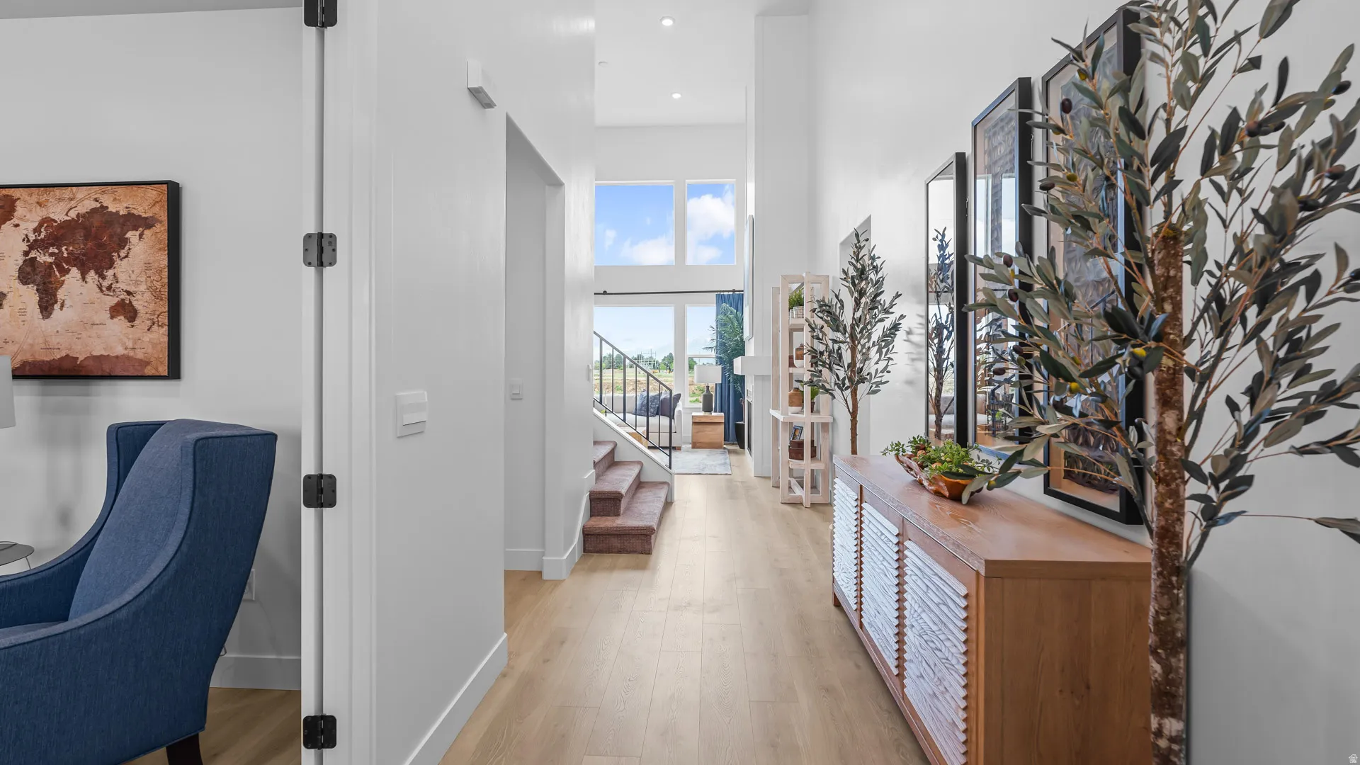 Light wood-finish flooring, high ceilings, and a built-in console table with slatted doors