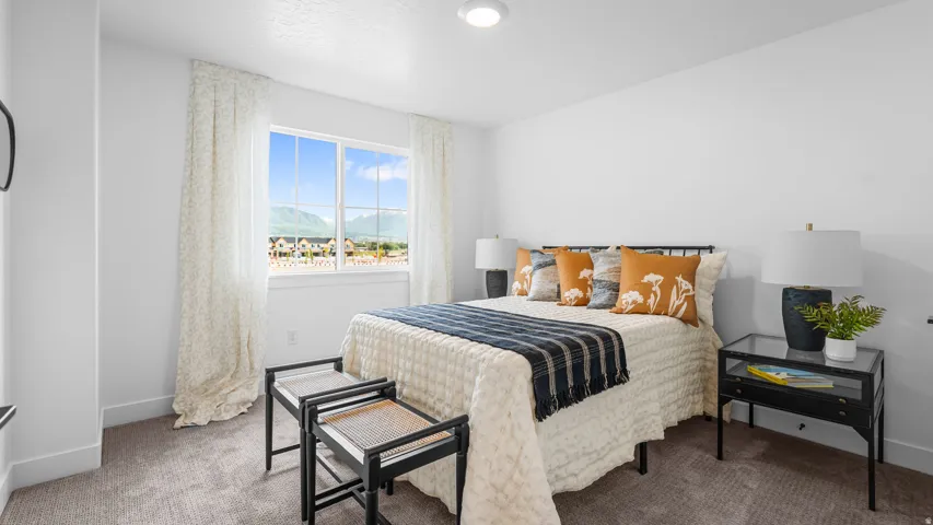Bright bedroom featuring a large window, neutral carpeting, recessed lighting, and white walls