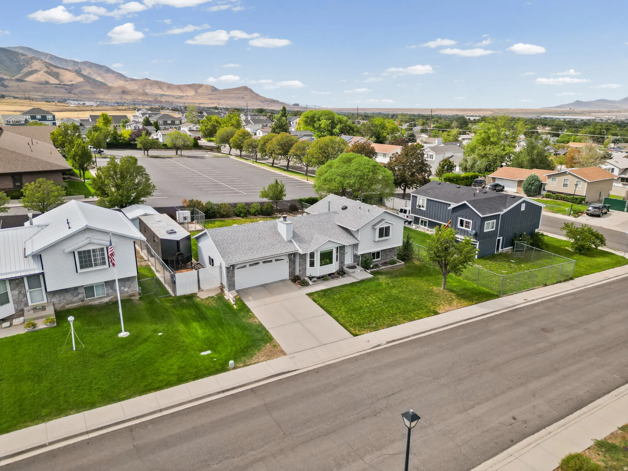 An attached two-car garage, concrete driveway, and a manicured front lawn