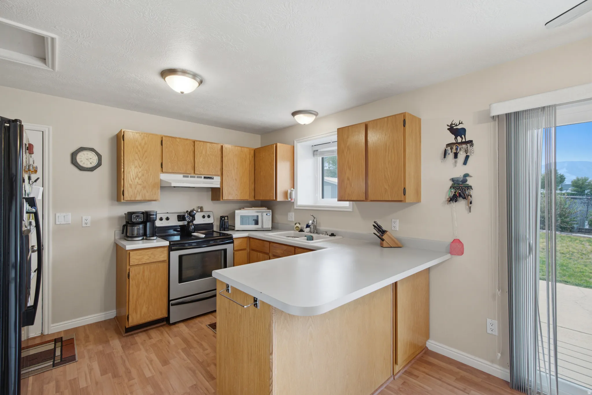 Kitchen featuring wood-finish cabinetry, light-toned countertops, and a sliding glass door