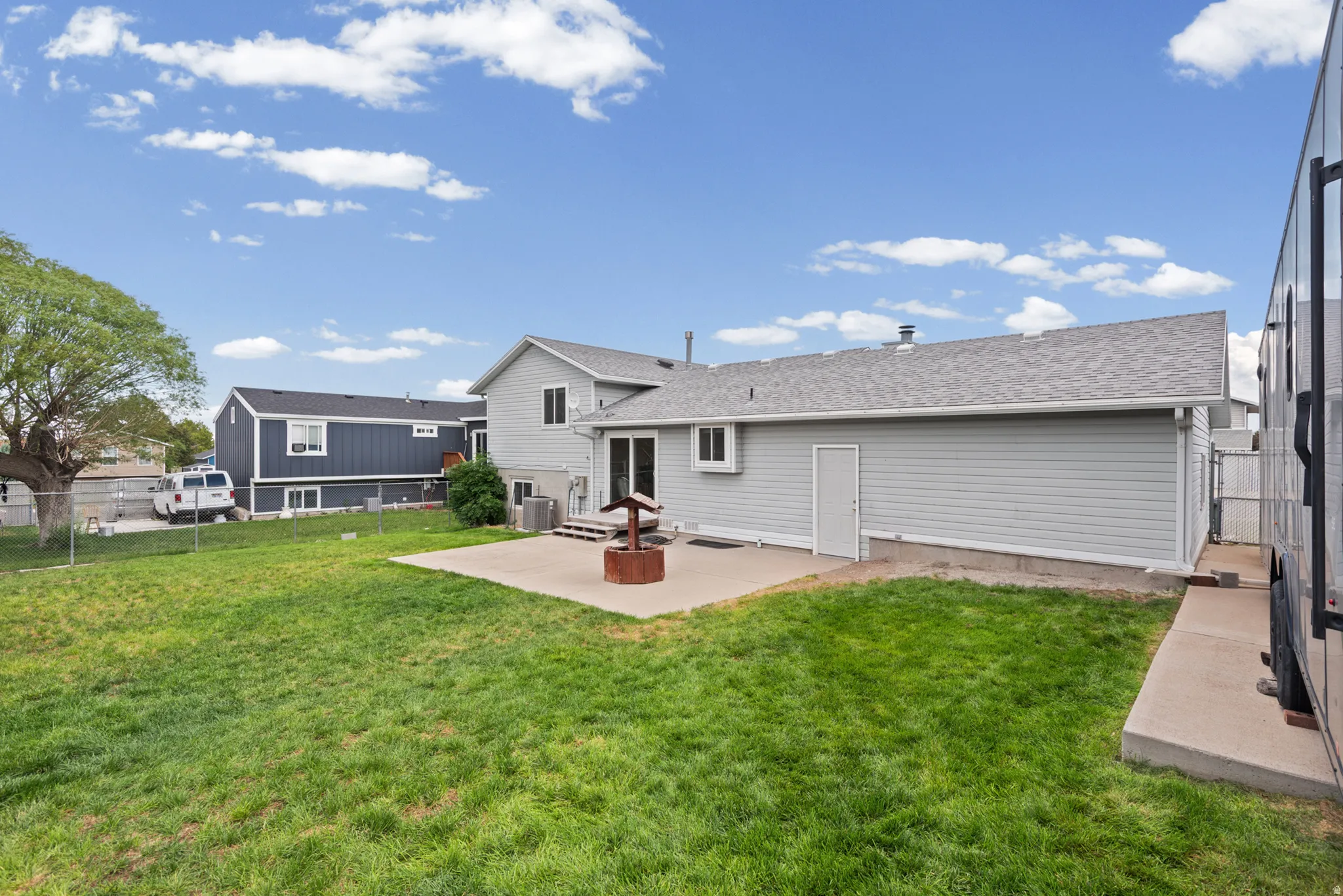 Spacious backyard featuring a manicured lawn, mature landscaping, and a composite deck with direct access to the home