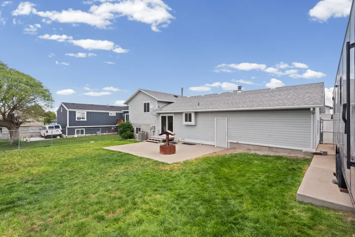 Spacious backyard featuring a manicured lawn, mature landscaping, and a composite deck with direct access to the home
