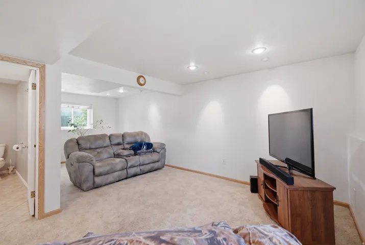 Recessed ceiling lighting, light-colored carpeting, a window, and wood-finish trim