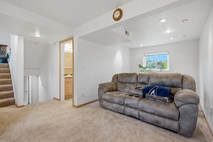 Carpeted flooring throughout, recessed lighting, white walls, and a window providing natural light