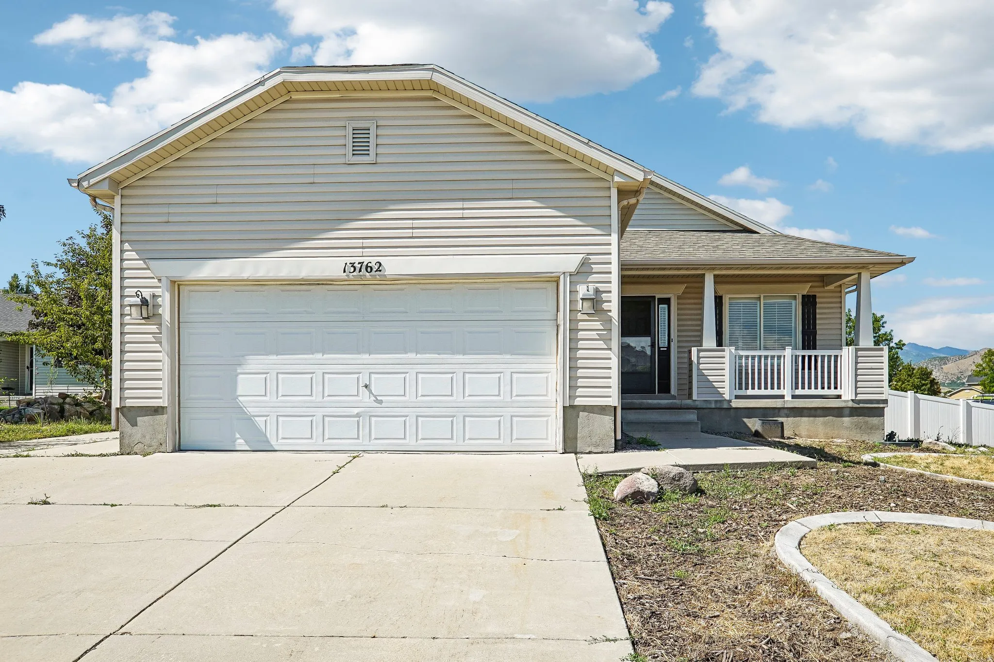 Siding exterior with an attached garage, covered front porch, and concrete driveway