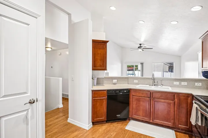 Kitchen featuring wood-finish flooring, recessed lighting, and a white double-basin sink with a gooseneck faucet
