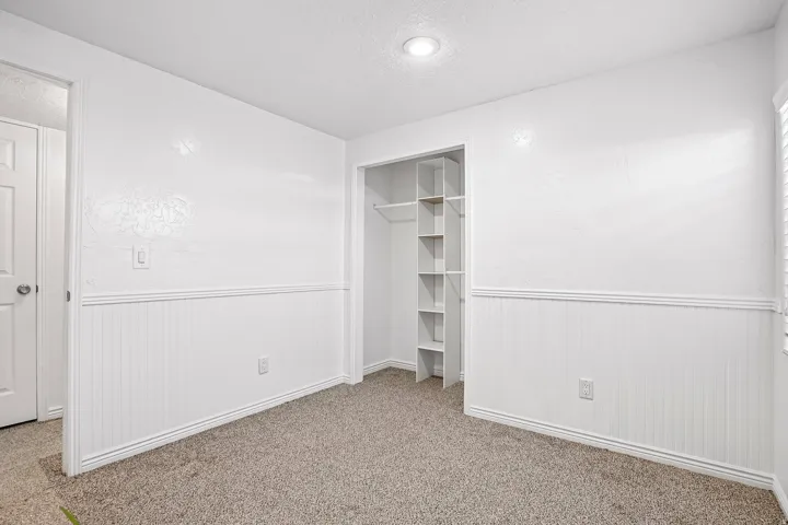 Wall-to-wall carpeting, recessed ceiling lighting, and beadboard wainscoting