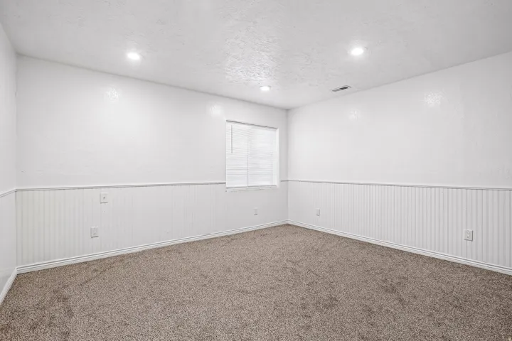 Wall-to-wall carpeting, recessed ceiling lighting, and beadboard wainscoting