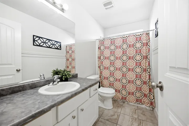 White vanity with an integrated sink and chrome faucet, set against a wainscoting wall panel