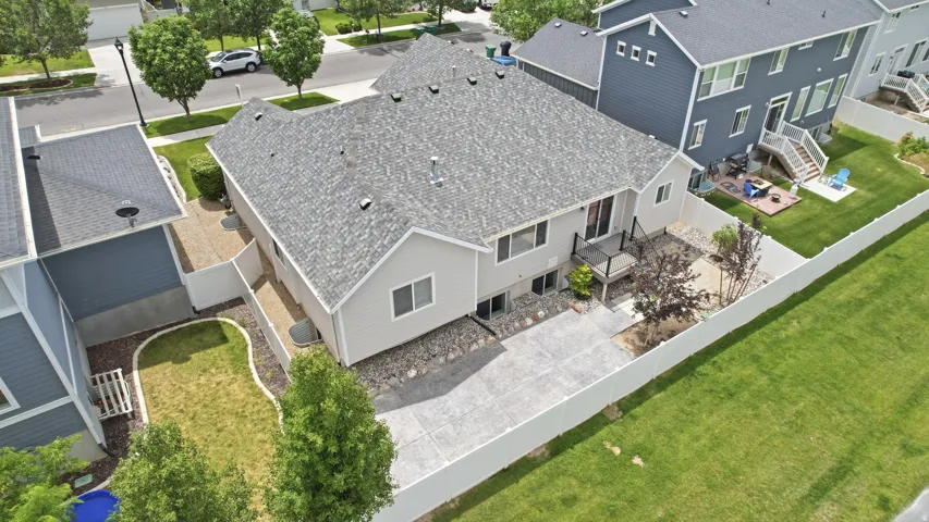 Rear exterior featuring a composite deck, concrete patio, and a privacy fence