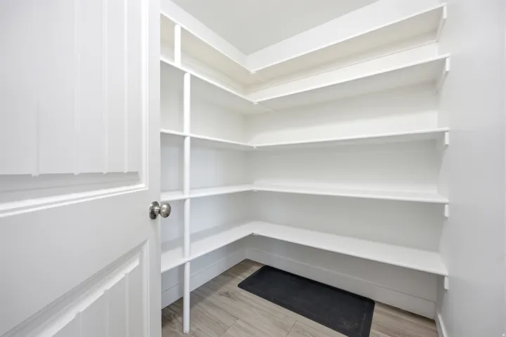 Built-in shelving, wood-finish flooring, and a paneled door