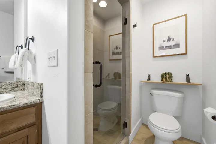 Built-in vanity with a granite countertop and wood-finish cabinetry