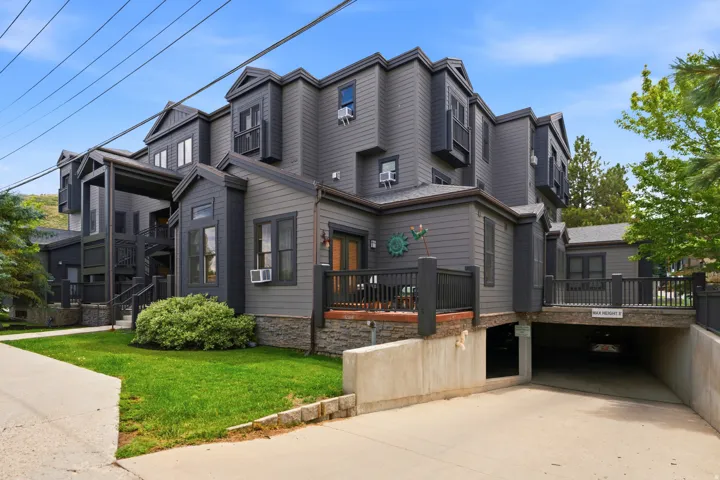Multi-level exterior with dark gray siding and stone foundation accents