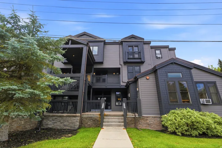 Multi-level facade featuring horizontal siding and dark shingle accents