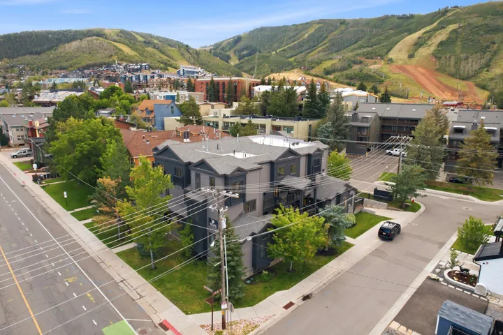 Modern multi-story building featuring a dark gray exterior and light gray roof