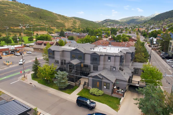 Multi-level gray exterior with multiple balconies and pitched shingle roofs