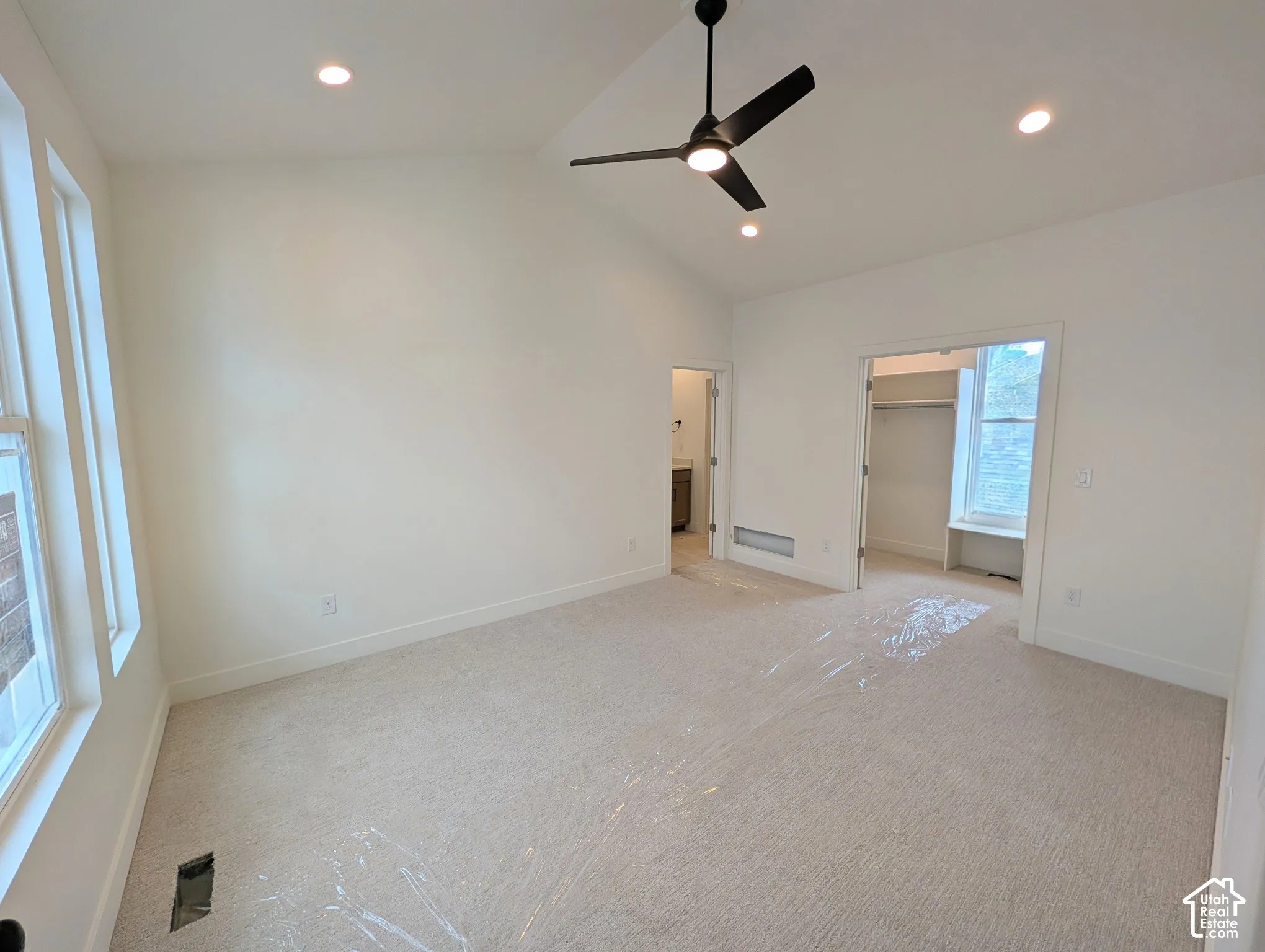 Vaulted ceiling with recessed lighting, ceiling fan, carpeted flooring, and multiple windows