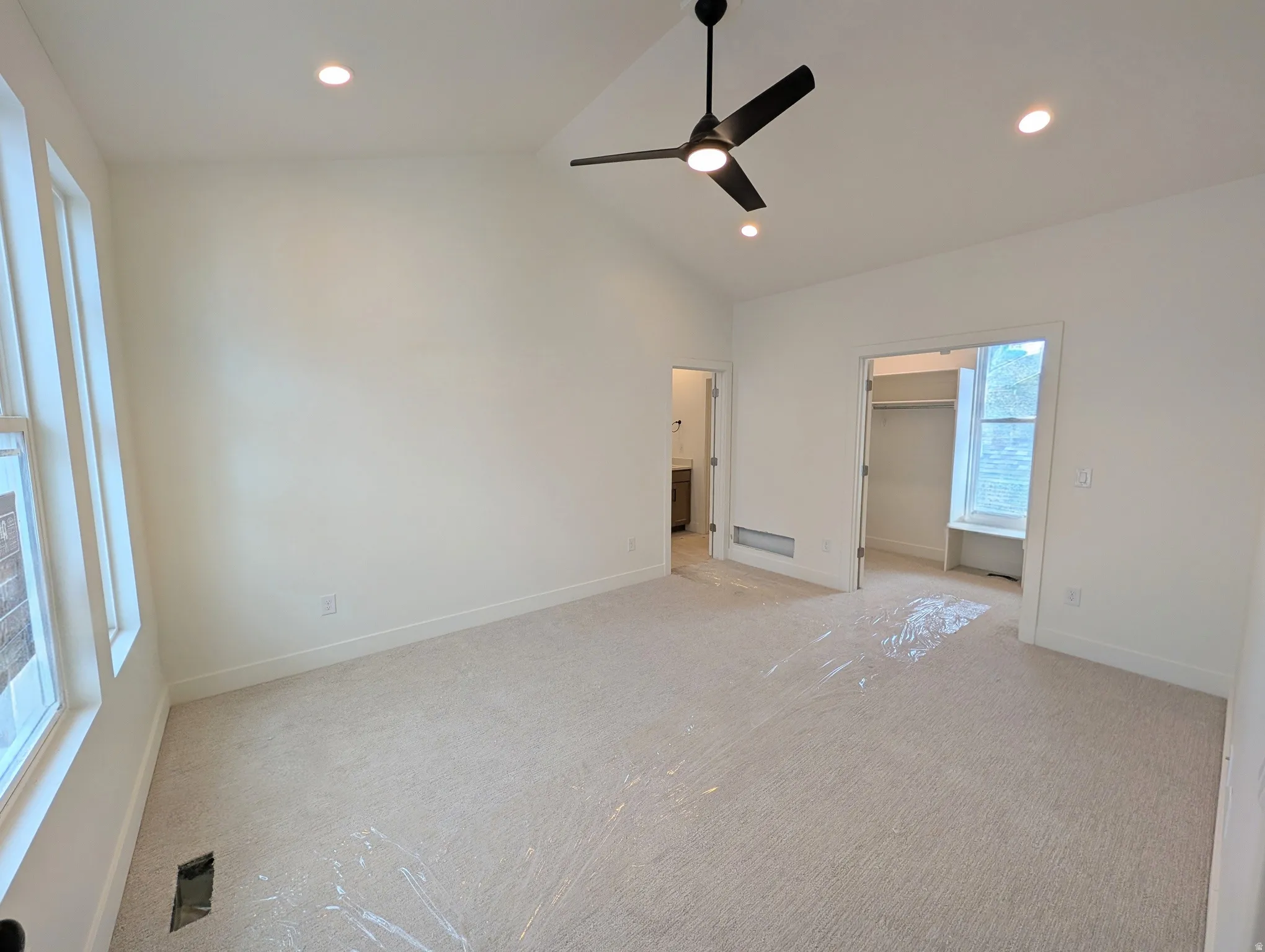 Vaulted ceiling with recessed lighting, ceiling fan, carpeted flooring, and multiple windows