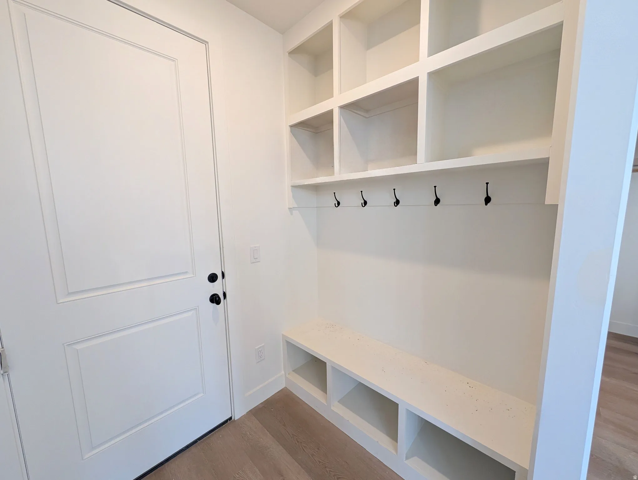 Built-in cubbies and shelving, integrated bench seating, and five wall-mounted hooks