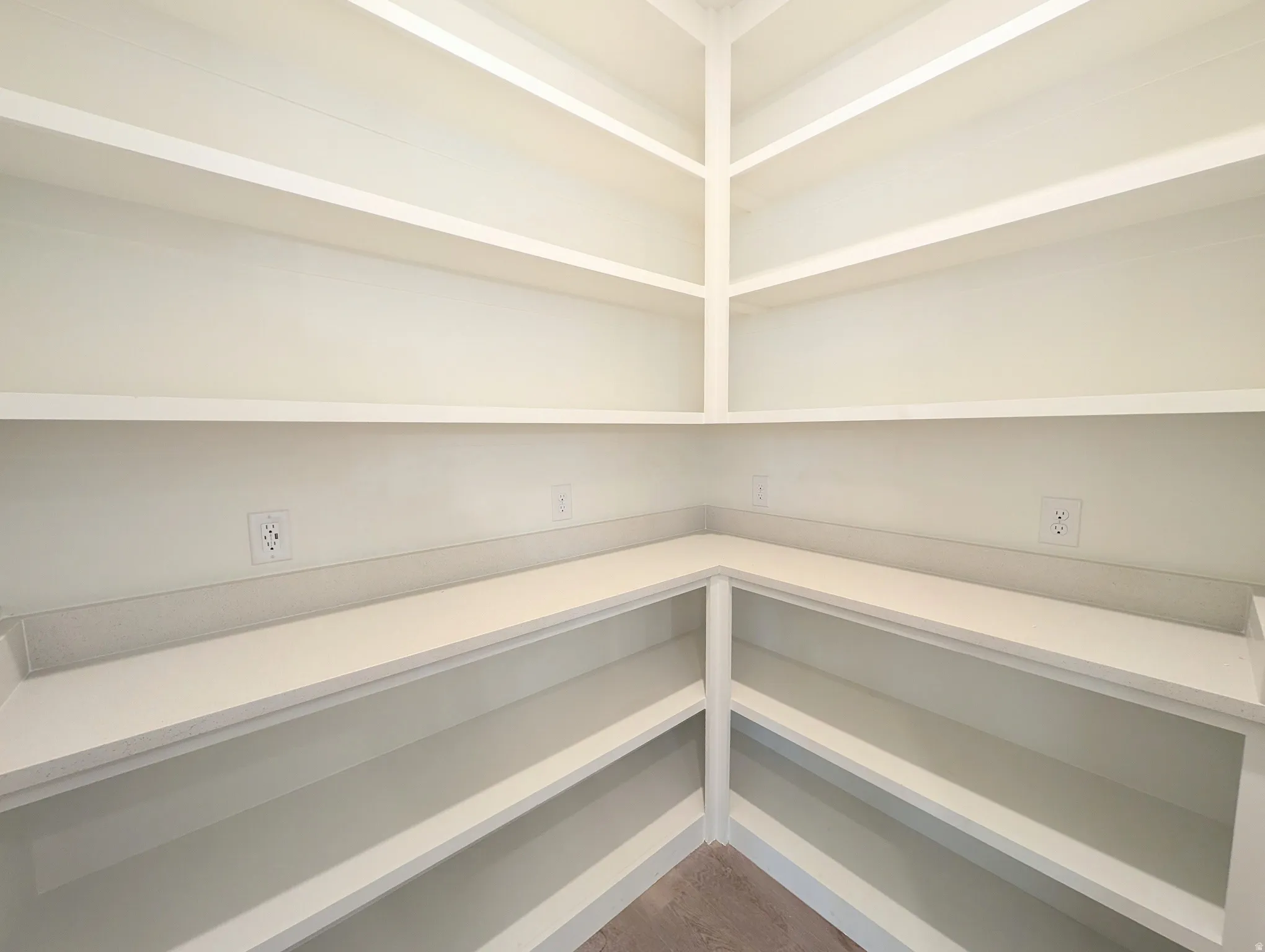 Built-in shelving with multiple levels, corner countertop, and integrated electrical outlets