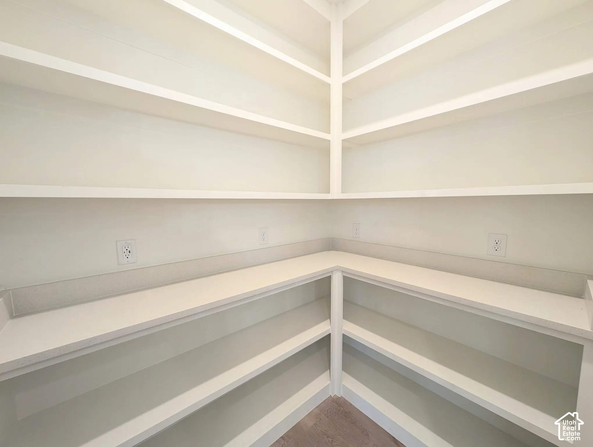 Built-in shelving with multiple levels, corner countertop, and integrated electrical outlets