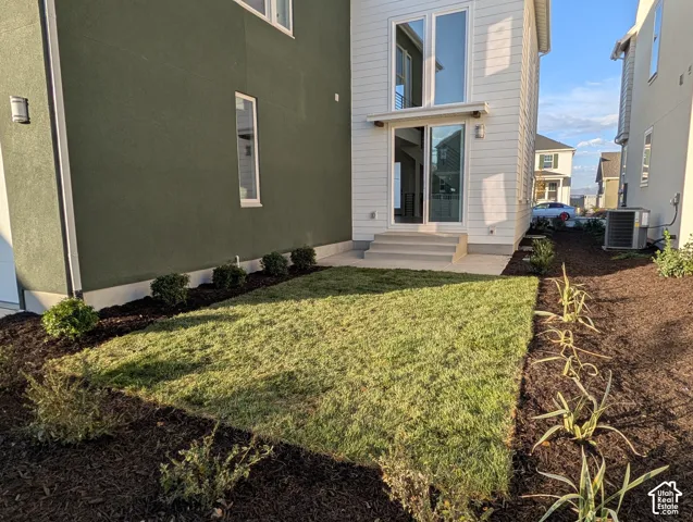 Landscaped backyard with fresh sod, dark mulch beds, and established plantings