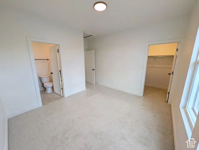 Bedroom #3. Neutral-toned carpeting, white walls, flush-mount ceiling light, window, and a closet with shelving
