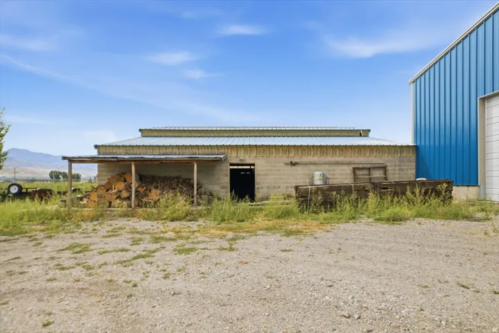 Concrete block structure with a corrugated metal roof, featuring an attached covered lean-to