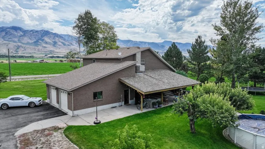 Brown brick exterior with a two-car garage, covered patio, and above-ground pool
